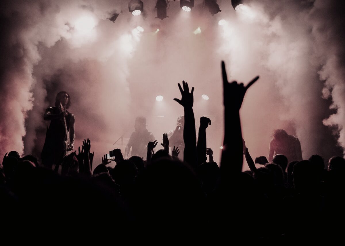 A concert crowd with hands raised