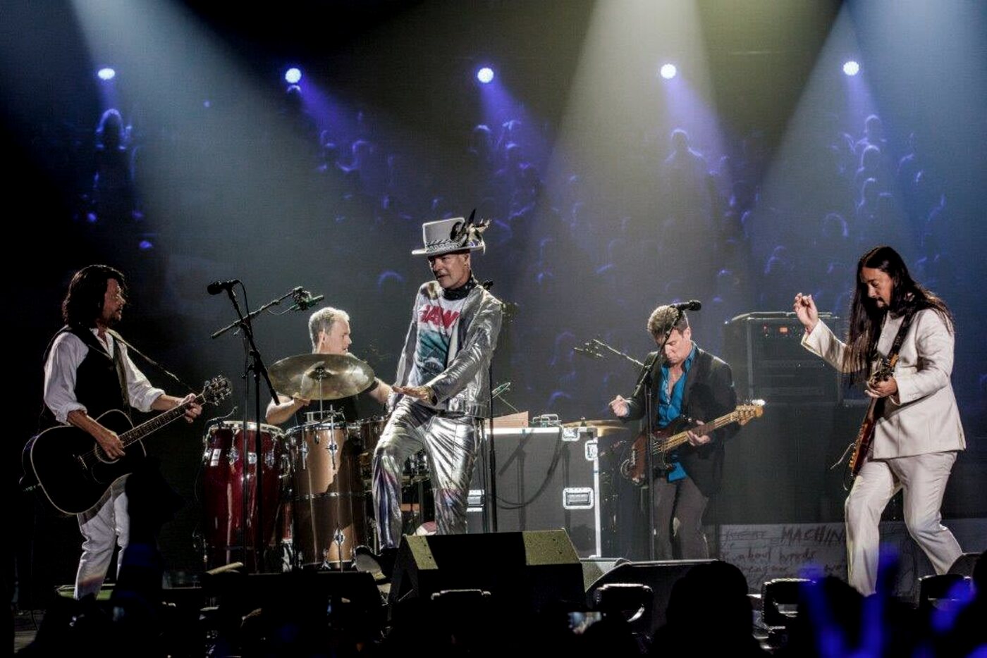 A rock band performing live under stage lights