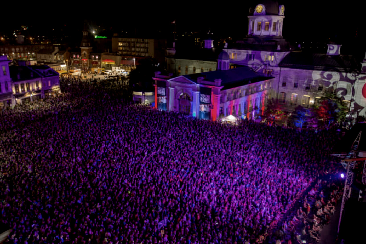 A large outdoor concert crowd at dusk